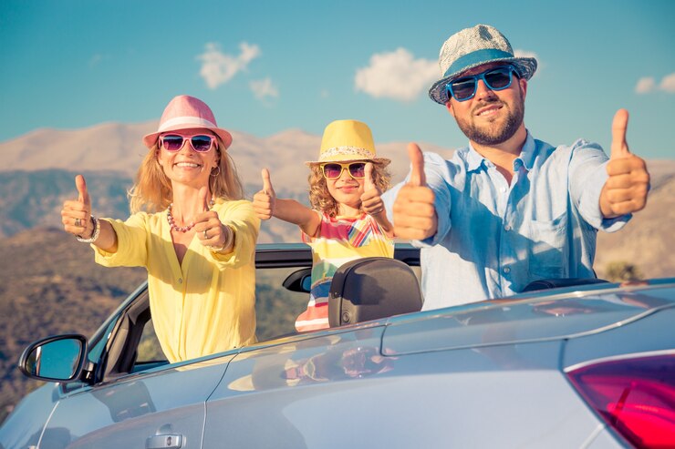 happy-family-with-colorful-hats-their-convertible-car-roof-doing-ok-sign-with-mountain-background_411285-6144